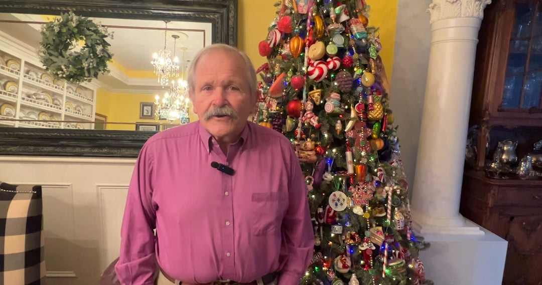 Jim Shore standing by a Christmas tree